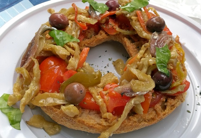 Fresella (hartes Brot) mit in Olivenöl eingelegten Auberginen, Tomaten, Oliven und Sardellen(Ristoro Pozzallo in Lentiscosa di Camerota)